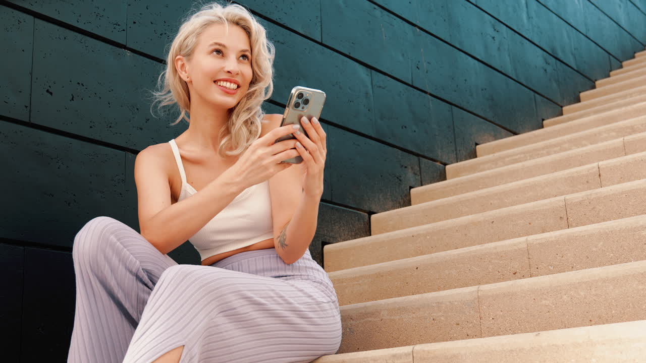 Frau mit Handy auf Treppen