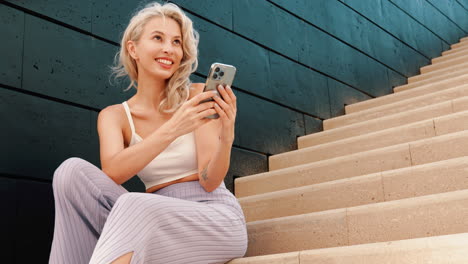 mujer usando el teléfono en las escaleras