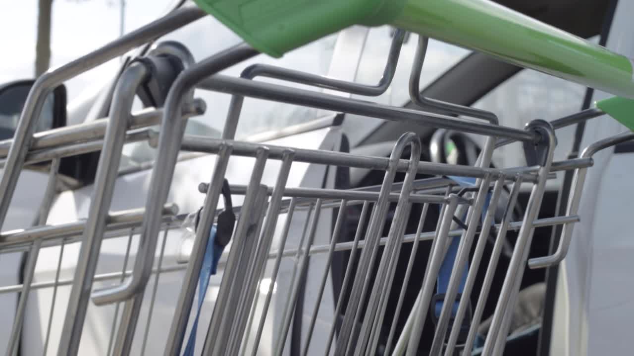 Supermarket shoppping trolley cart parked near a vehicle crane tilting shot