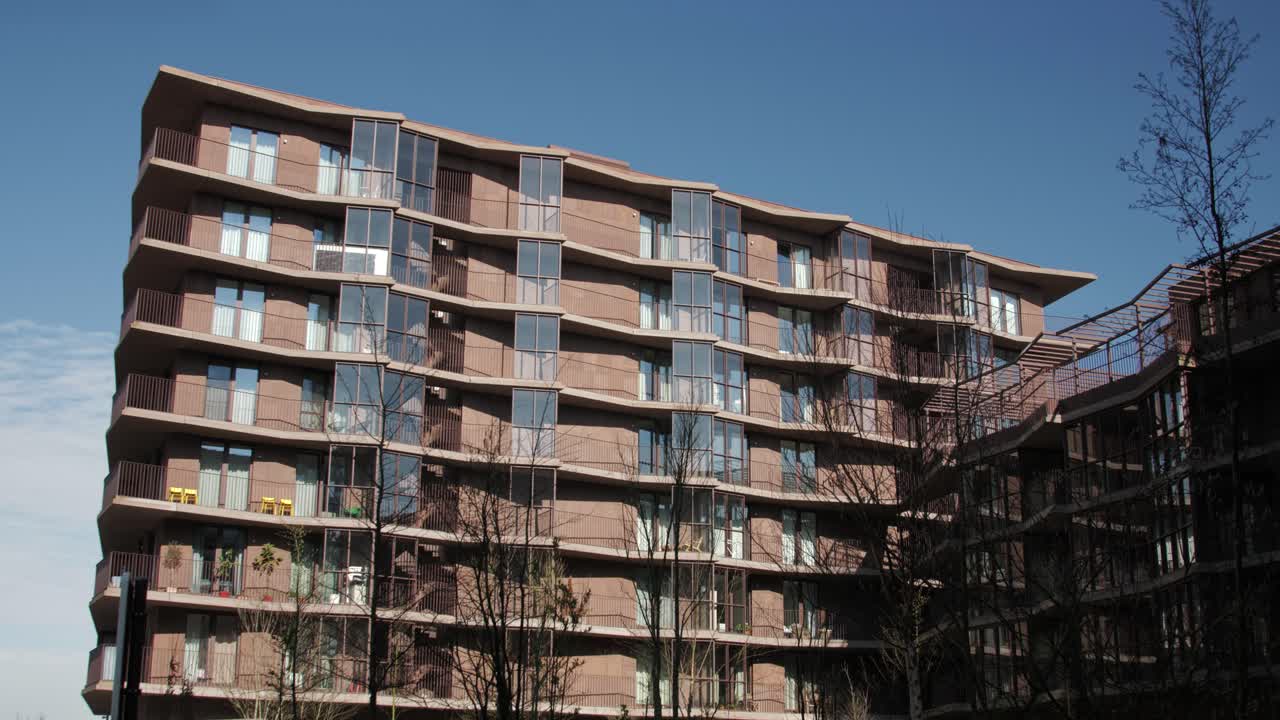 Unique residential complex featuring curved balconies, textured facade and warm-toned materials