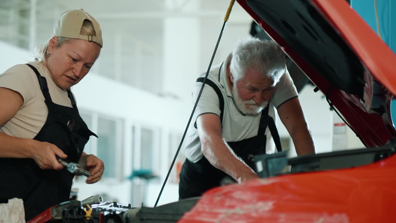 mecánica de automóviles chequeando y trabajando en un taller de reparación de automóviles. mujer adulta usando una llave de tornillo para apretar los tornillos de una parte del motor.