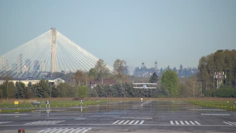 Biplano-Acrobático-Despega-Desde-La-Pista-Detrás-De-Un-Disparo-Con-Lente-Larga