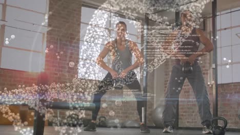 Medizinische-Datenverarbeitung-Gegen-Gemischtrassiges,-Fittes-Paar,-Das-Im-Fitnessstudio-Mit-Kettlebells-Trainiert