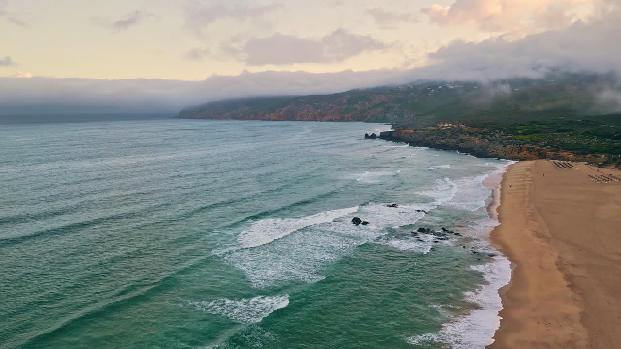 Vista drone delle onde tempestose dell'oceano che schiumano sulla sabbia. Onde marine che lavano la spiaggia sabbiosa
