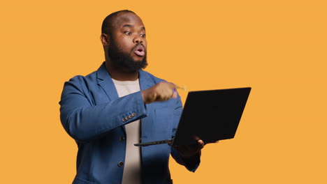 Person-showing-disagreeing-sign-during-meeting-using-laptop,-studio-background