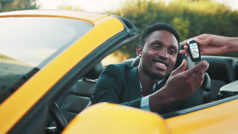 man receiving car keys in convertible