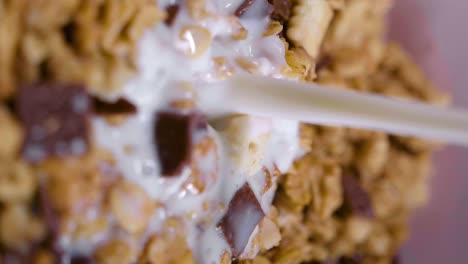 primer plano en cámara lenta de la leche que se vierte en un vaso de cereal, disparo vertical