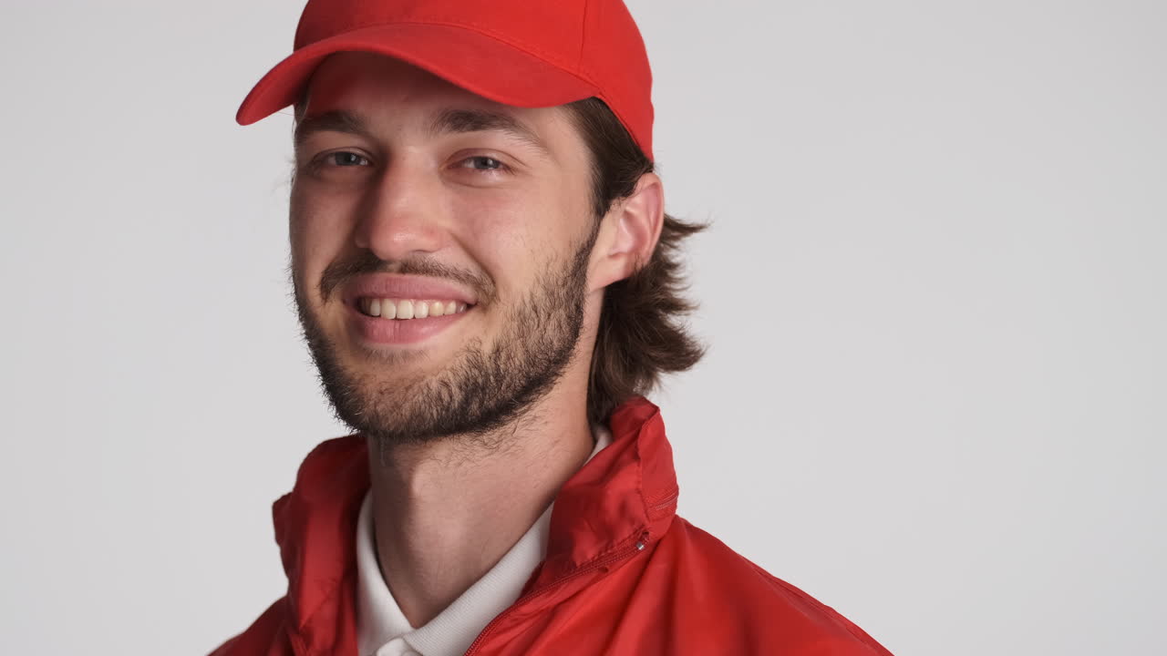 el repartidor caucásico frente a la cámara sobre un fondo blanco.