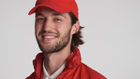 caucasian delivery man in front of camera on white background.