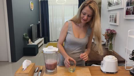 woman making a smoothie in her kitchen