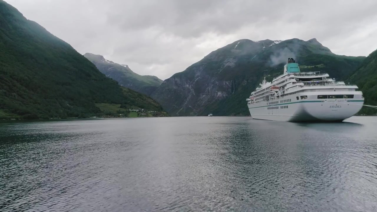 Luftoptagelse i slowmotion, der flyver lavt mod et norsk skib med røg, og flyver op til sidst.