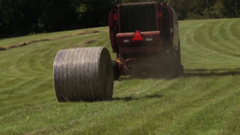 una macchina di baler che fa pile rotonde di fieno nei campi