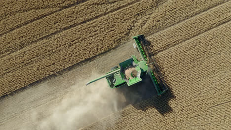 top view of harvesting combine working on field in saskatchewan, canada