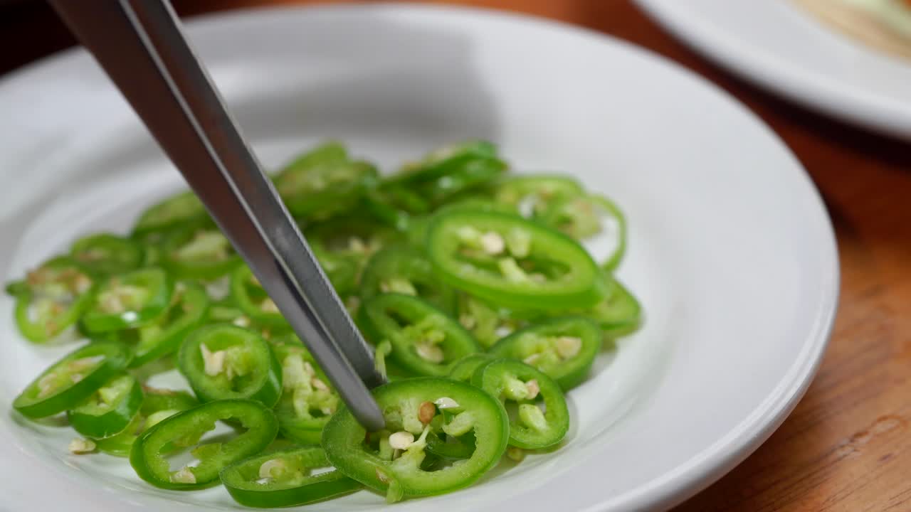Latin chef putting chili on top on gourmet taco fish shrimp baja california style