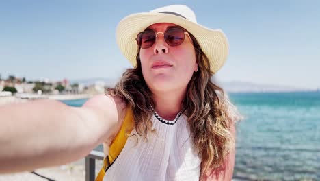 greek travel story: vlogger speaks to camera by the sea