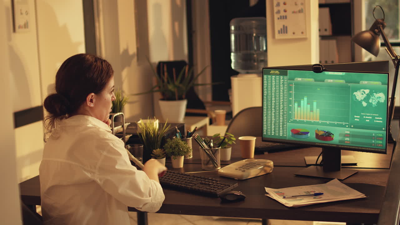 Manager answering landline phone call and analyzing financial report