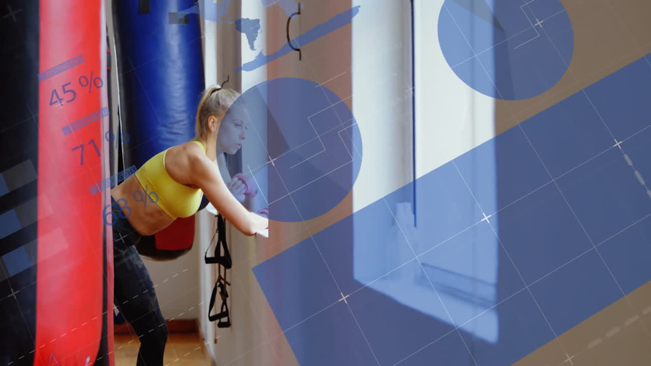 Athletic woman leaning into punching bag in fitness studio, showing animated percentage graphs