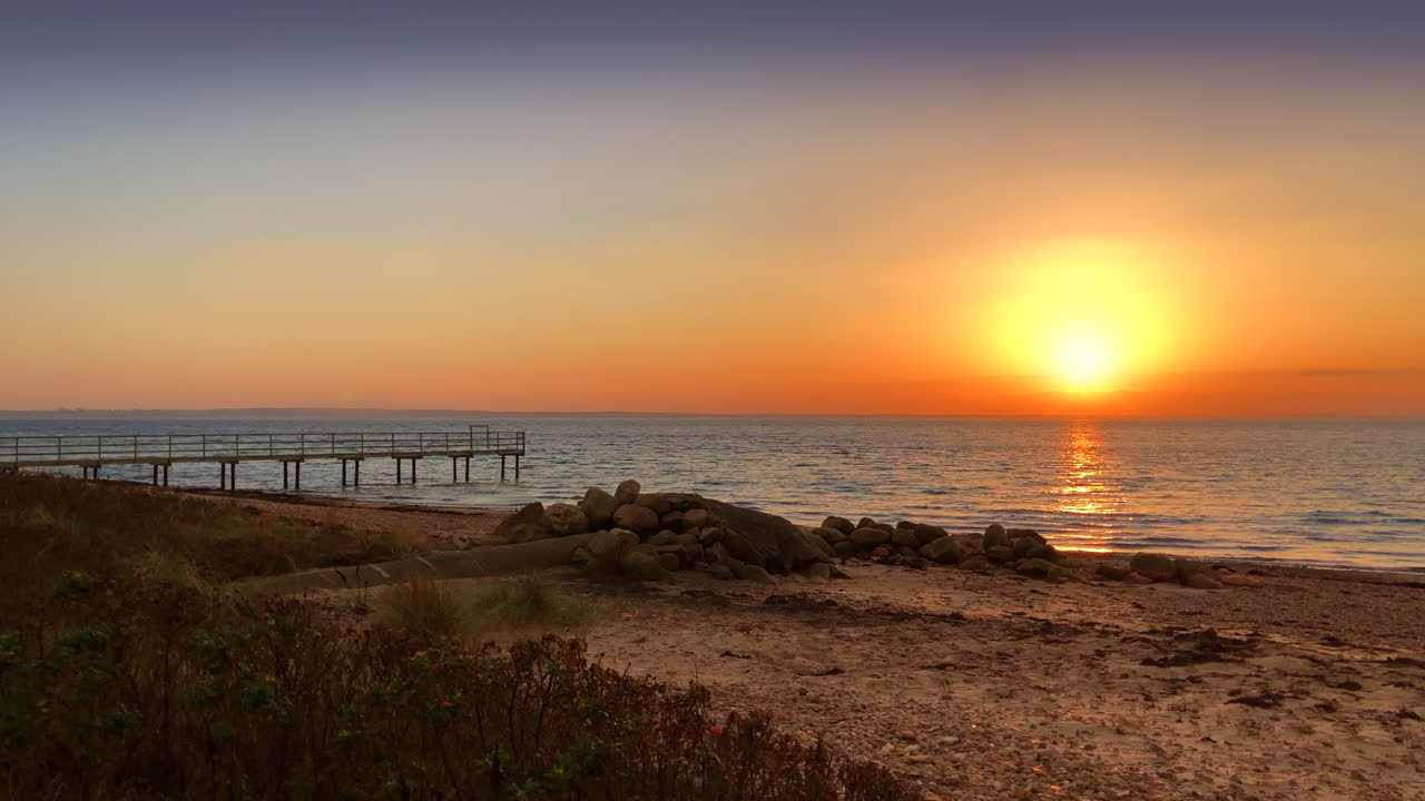 보드 워크 근처 해변의 놀라운 일몰