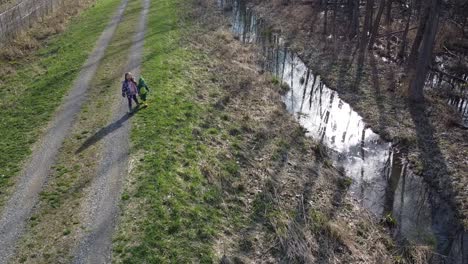 cute children holding hands while walking on the trail at the park in monroe, michigan - aerial shot