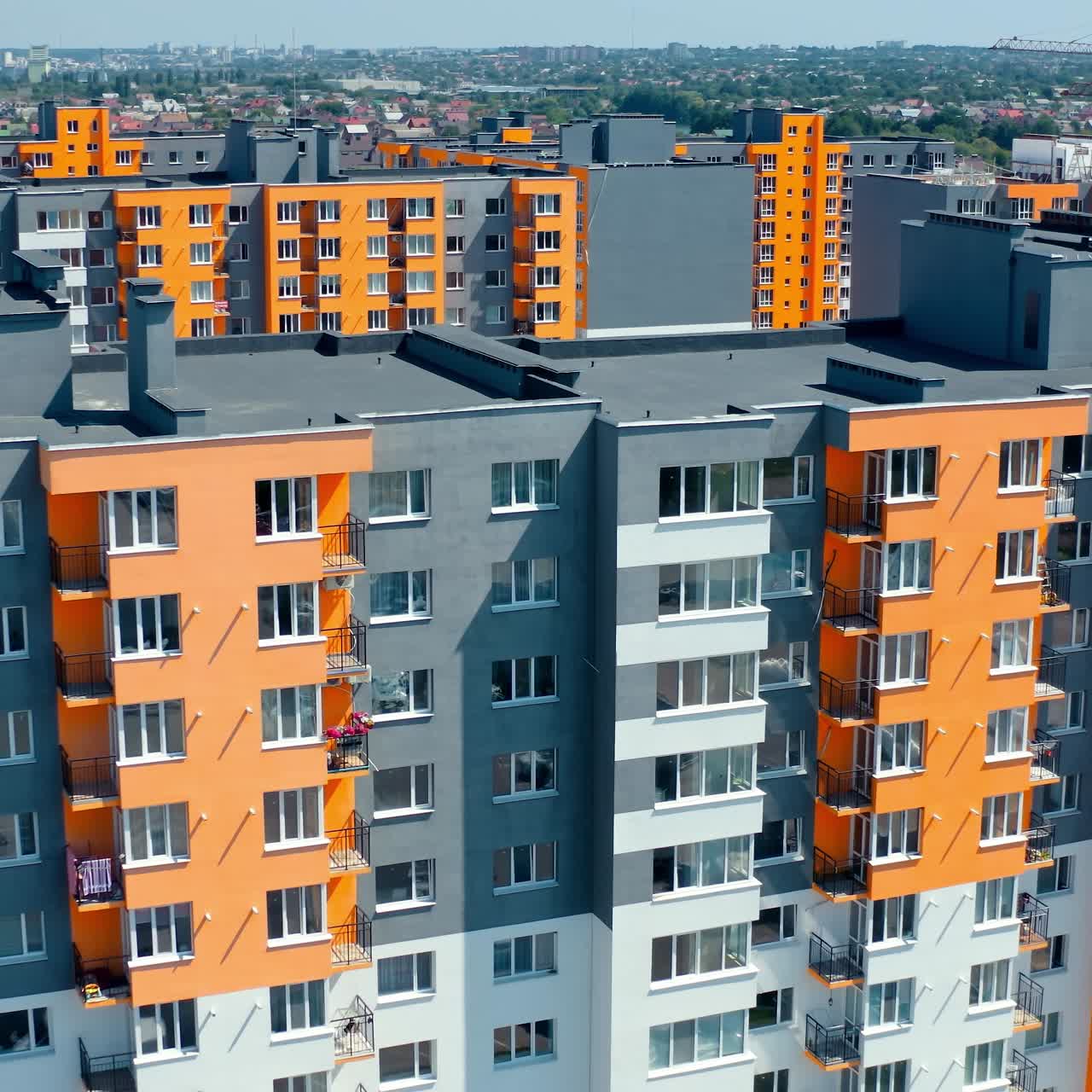 Facade of a modern apartment building. Colorful walls of a new multi-storey building with balconies and windows. High residential building in sunny day