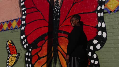 americus first friday art event artsapalooza, sumter county georgia young african american woman standing next to a large mural of a butterfly