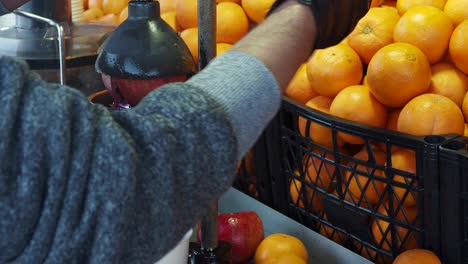 making fresh pomegranate juice at a market stall