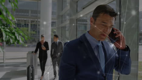 animation of network of connections against caucasian businessman talking on smartphone at office