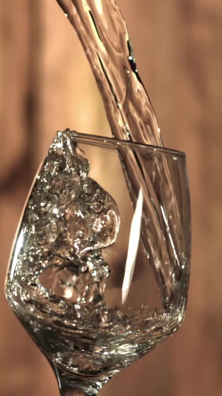 Acqua limpida versata in un bicchiere al rallentatore