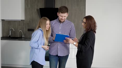 man and woman signing papers with real estate agent while making a deal and renting the apartment