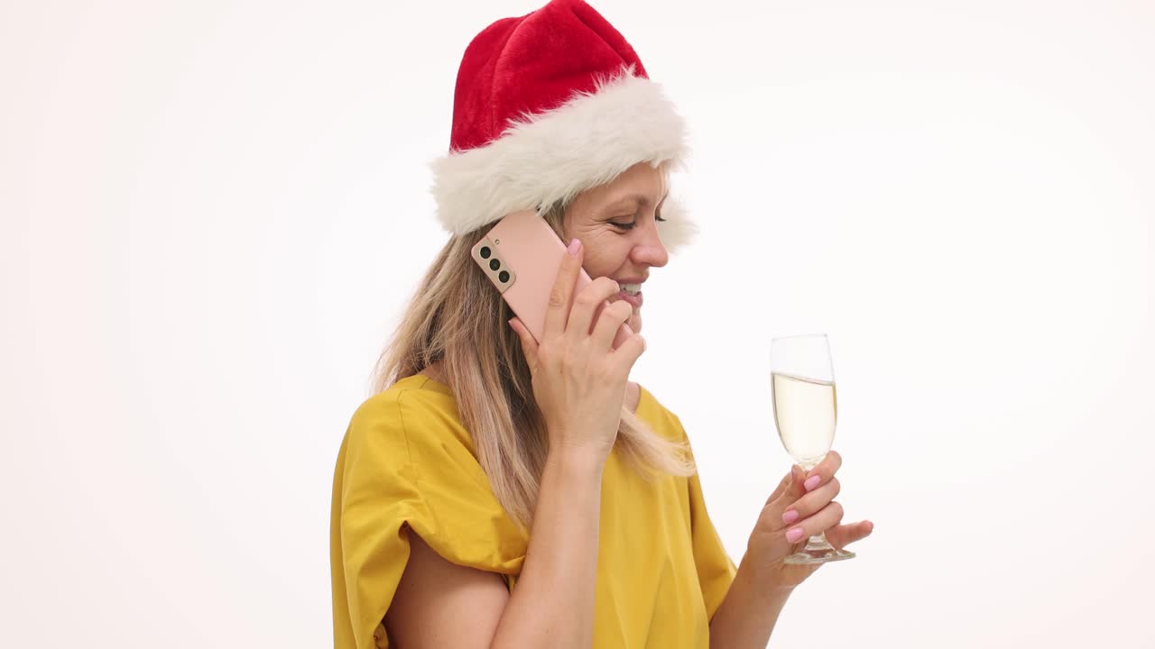 Festive Woman in Santa Hat Talking on Phone and Drinking Champagne