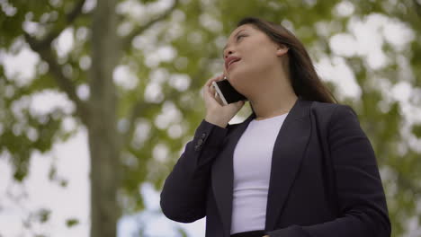 hermosa mujer joven hablando por teléfono inteligente al aire libre