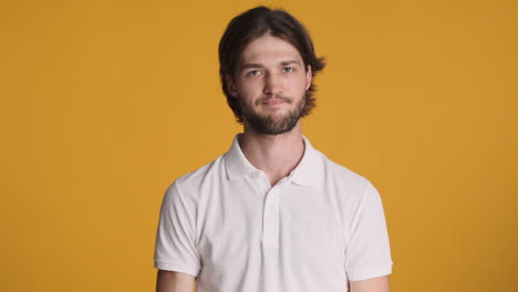 Caucasian man in front of camera on yellow background.