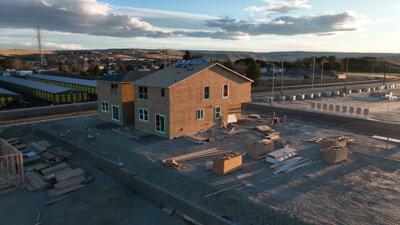 Orbiting aerial view of the first houses in a neighborhood being built at sunset