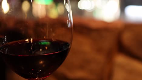 close-up of a red wine glass with a warm, blurred background creating a cozy ambiance.