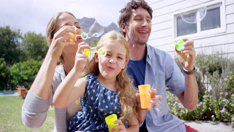 family playing with bubbles in the garden