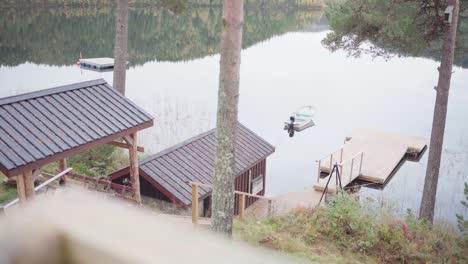 Boat-Floating-On-Calm-Waters-Of-Lake-With-Reflection-Of-Forest-And-Mountain