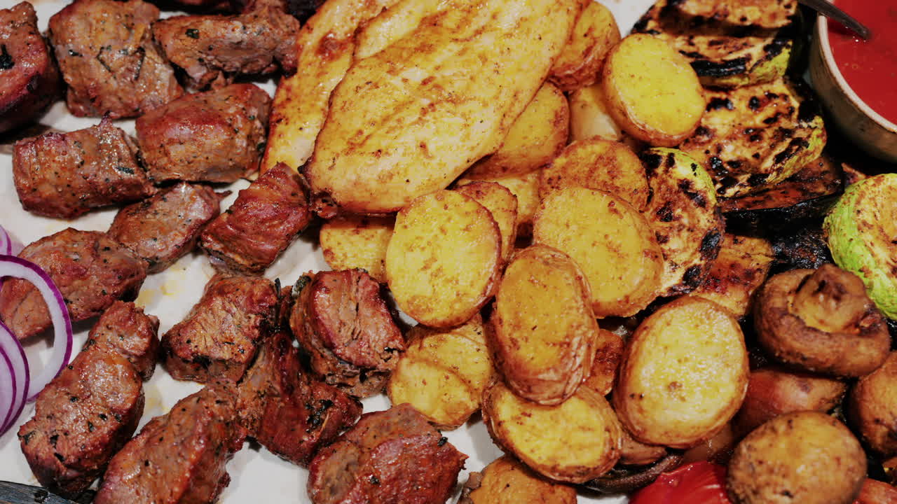 Juicy grilled meat served with golden roasted potatoes, tomatoes, mushrooms, and sauce