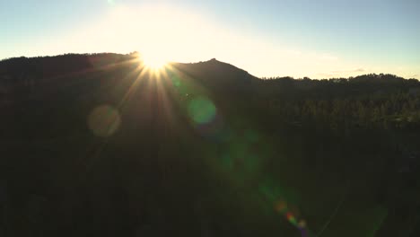 sun revealed behind a hilltop creating dramatic and