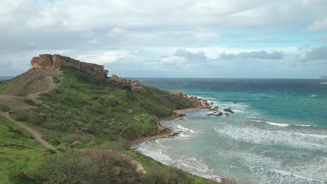 Antena:-Vista-Panorámica-De-La-Bahía-De-Gajn-Tuffieha-Y-La-Roca-Il-qarraba-En-Un-Día-Ventoso-Y-Brillante