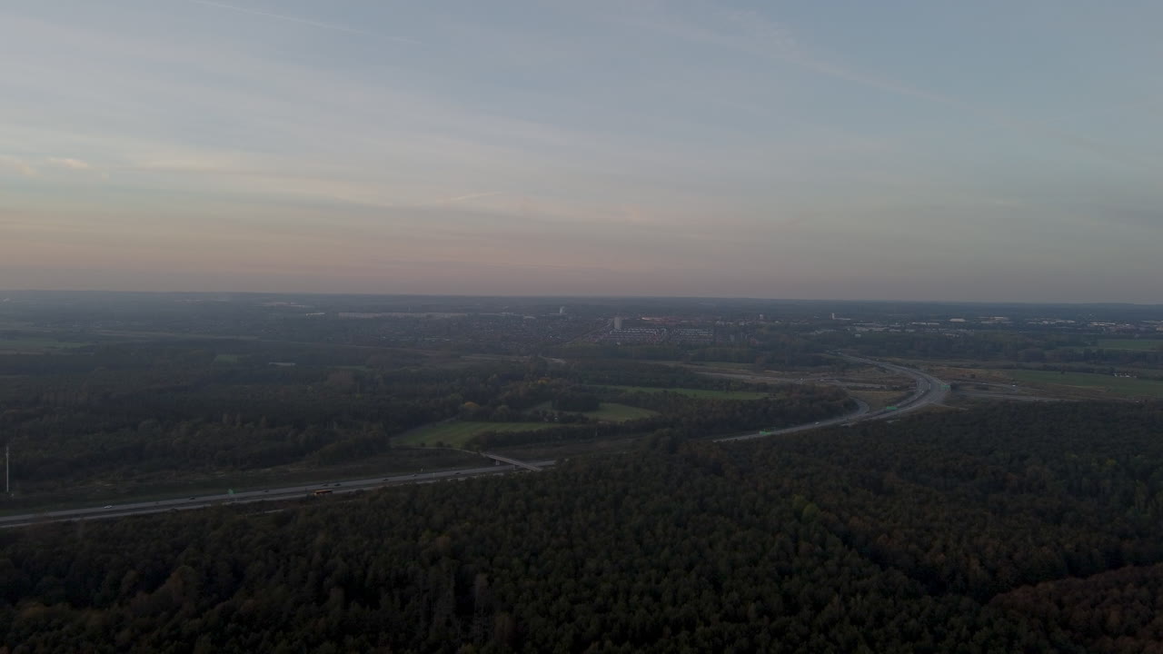 Drone Footage Of A Forest And A Highway during Sunset In Denmark