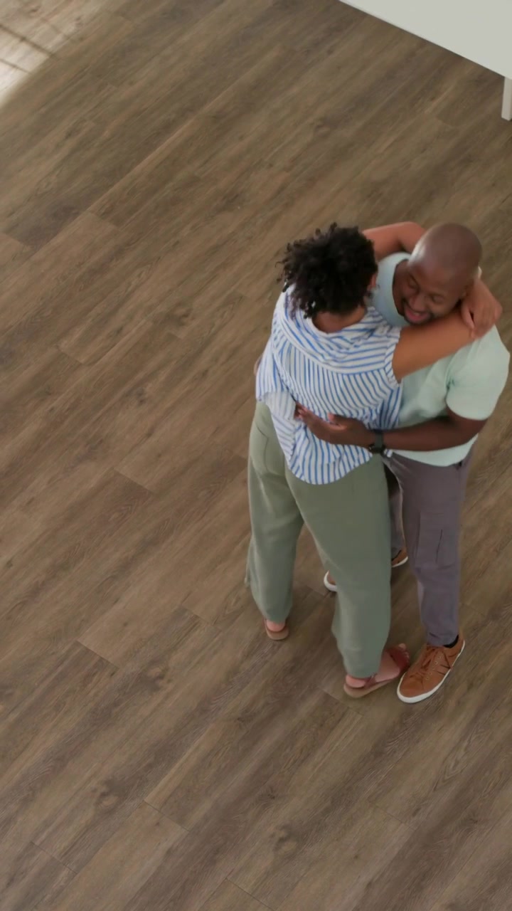 Vertical video: Walking woman starting hug with partner on wood floor with smartwatch, for comfort