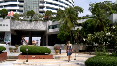 a woman walks down the street from the hotel building