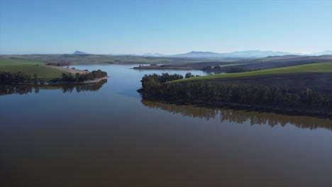 Aerial-drone-flying-over-lake-in-Spain-with-mountain-hills-in-background,-Seville