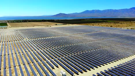 solar panel photovoltaic farm high aerial 4k drone sweep in and down toward salton sea in desert