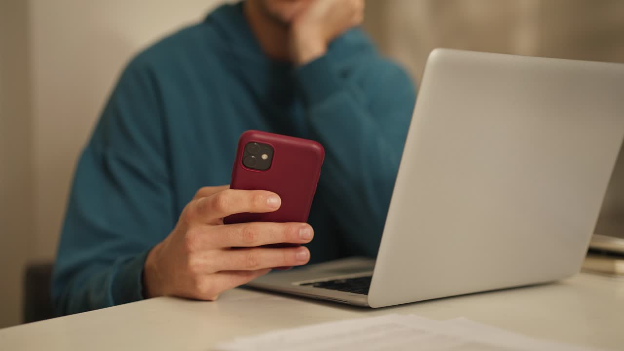 Man using phone and laptop