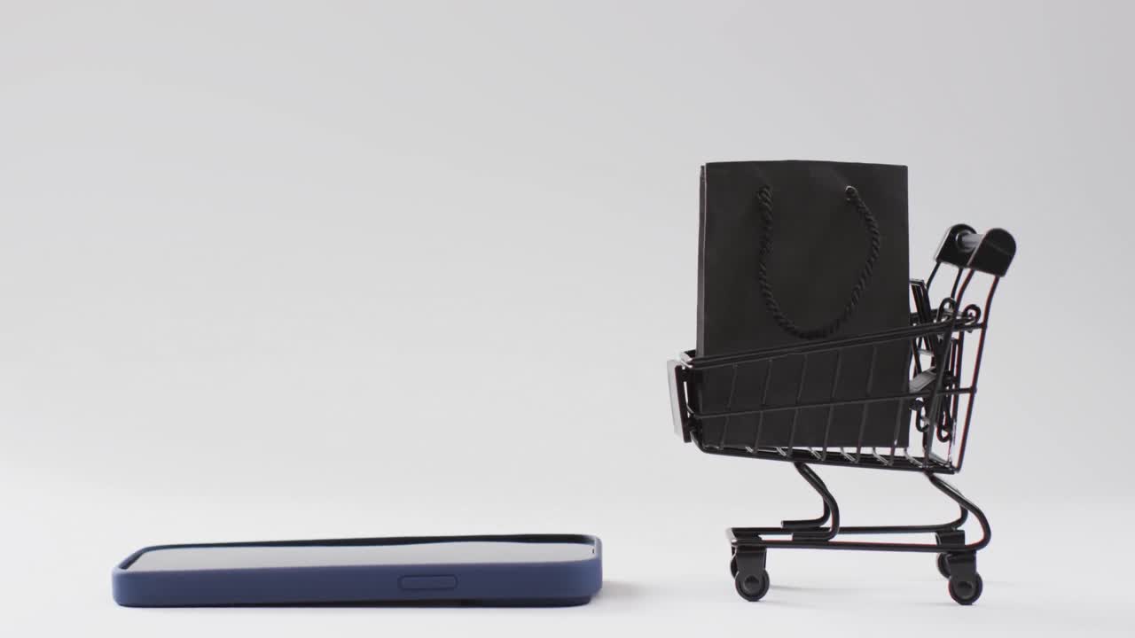 스마트 폰, 쇼핑 가방 및 트롤리 의 비디오 와 함께  ⁇  배경 에 복사 공간