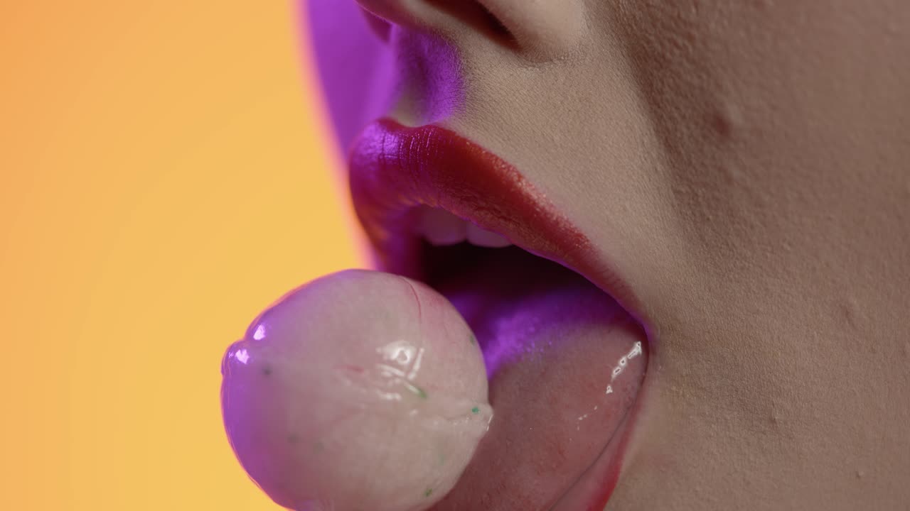 donna che leca il gelato, leca il rossetto, le labbra, la bocca in primo piano su sfondo giallo