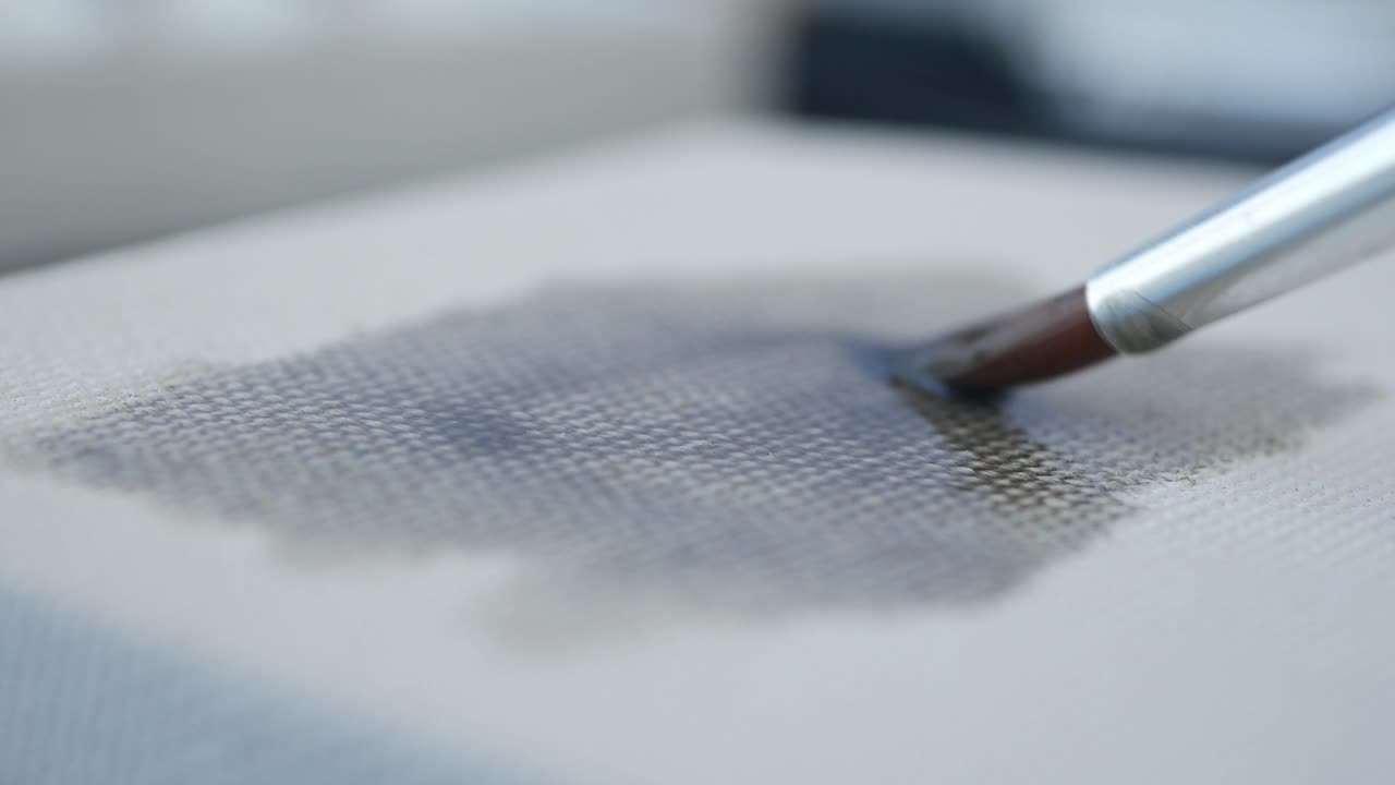 Artist painting on canvas with brush