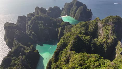 maya bay and pi leh bay, beach and lagoon with inlet, steep limestone cliffs covered tropical vegetation.