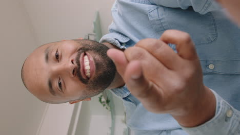 hombre joven atractivo teniendo video chat usando lenguaje de señas en el teléfono inteligente charlando compartiendo estilo de vida disfrutando de la comunicación en línea en casa en pantalla vertical